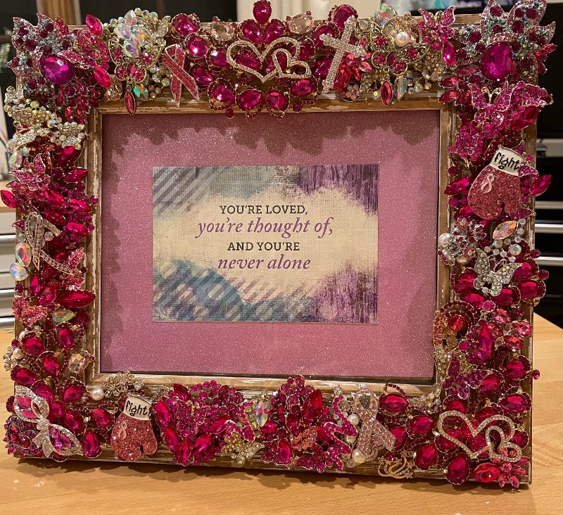 A picture frame with pink and red hearts on it.