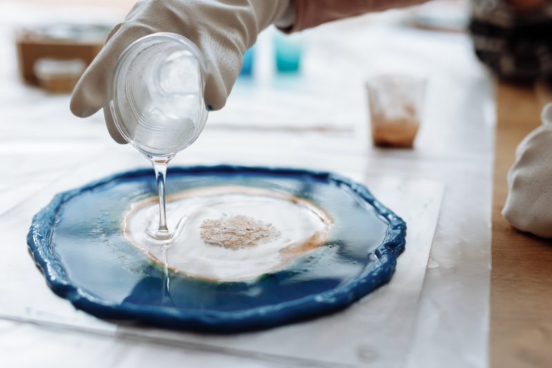 A person pouring liquid on top of a plate.