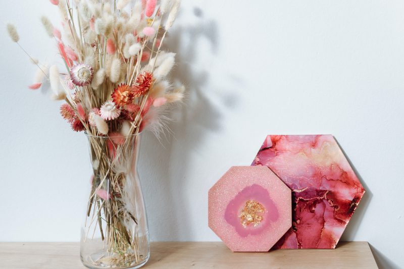 A vase of flowers and two boxes on a table.