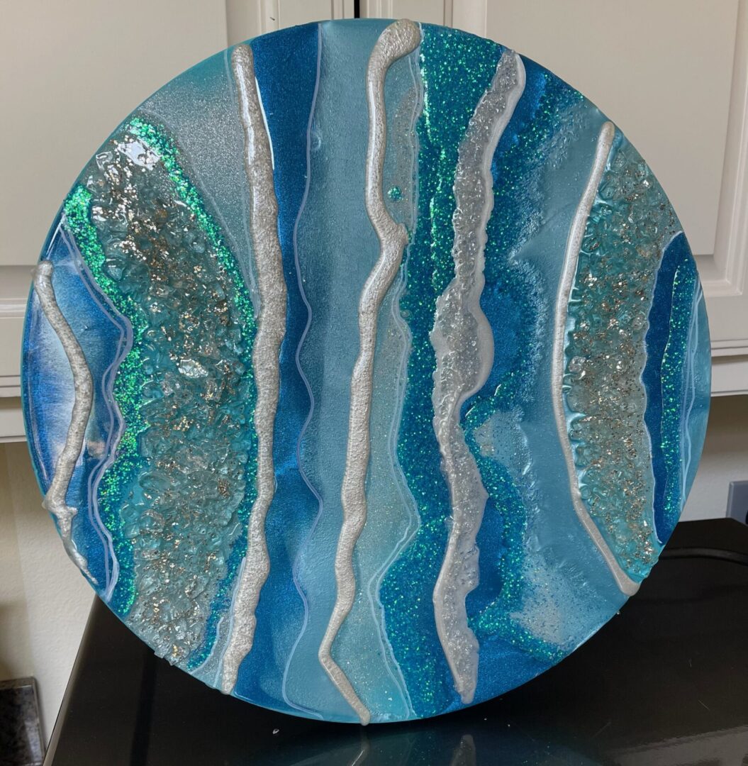 A blue plate with some silver and white paint