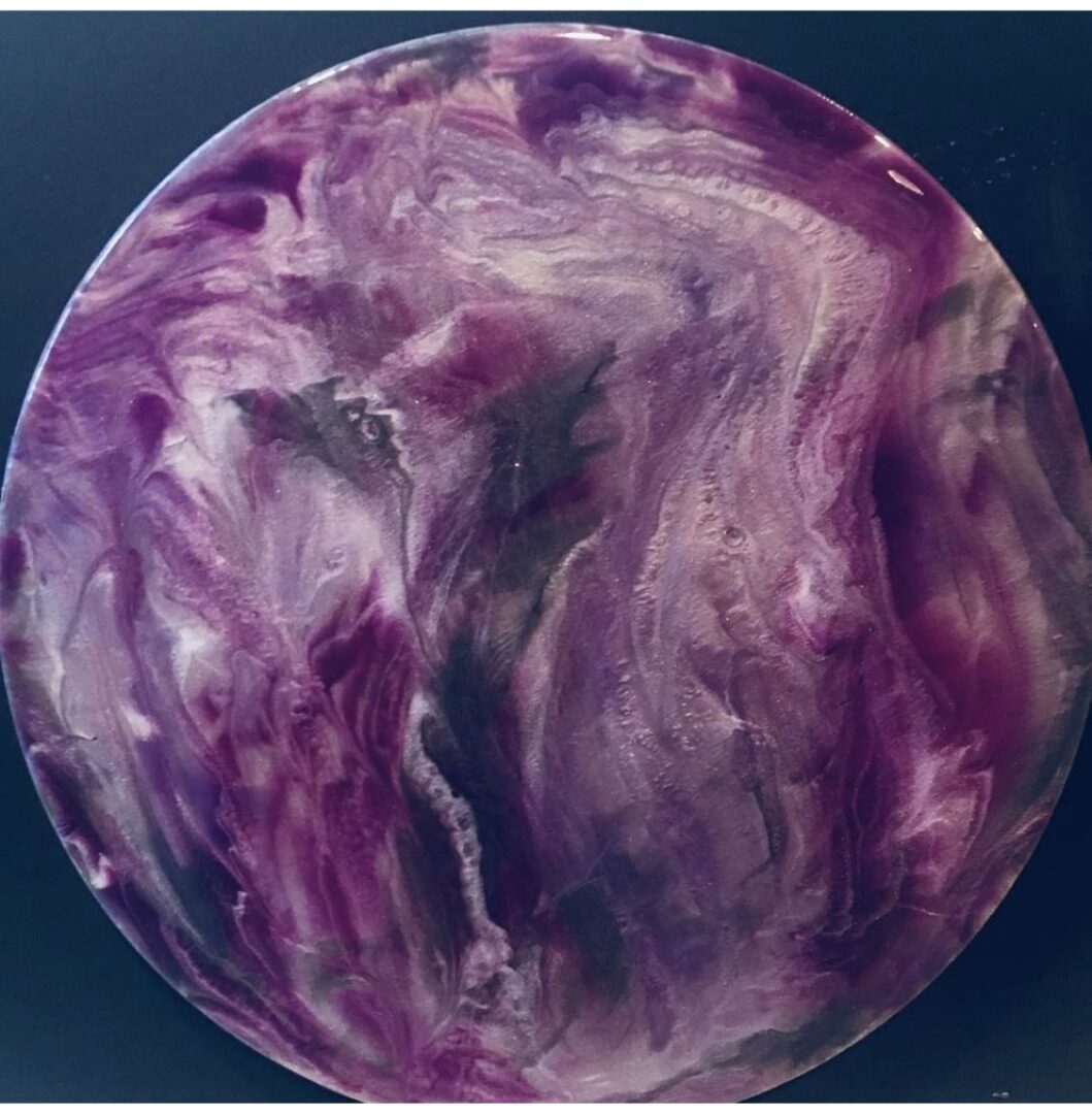 A purple ball with swirls of paint on it.