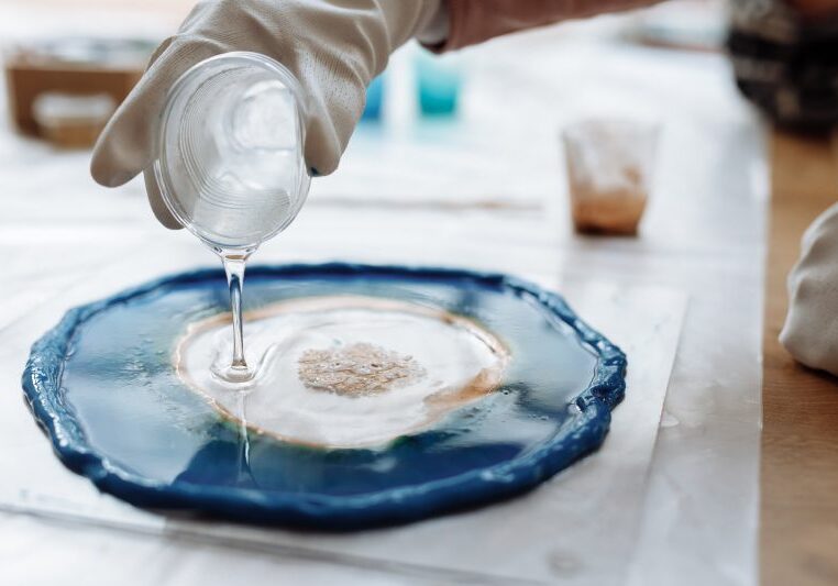 A person pouring liquid on top of a plate.